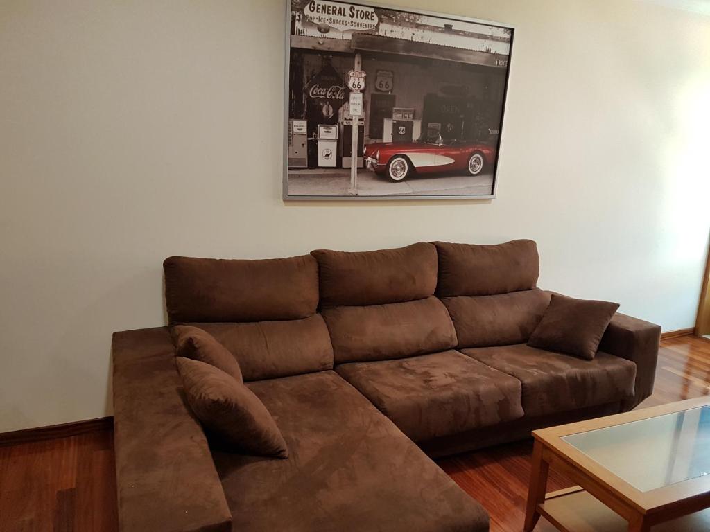 a brown couch in a living room with a car on the wall at Piso Maceira Combarro in Combarro