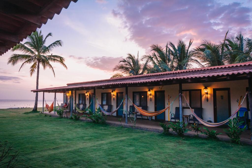 ein Haus mit einer Hängematte vor dem Meer in der Unterkunft Beach Break Hotel & Surf Camp de Playa Venao in Playa Venao