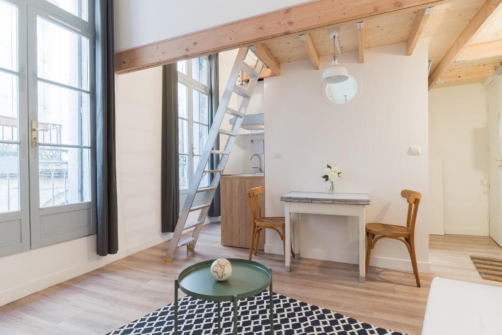 una habitación con una escalera, una mesa y un escritorio en L'Escale, en Montpellier