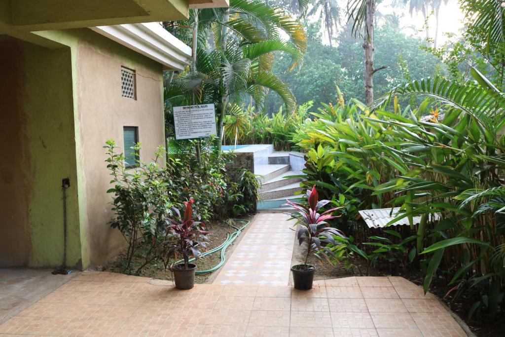 une passerelle menant à un bâtiment avec des plantes et des escaliers dans l'établissement Asian Golden Sands - S7 & S8, à Benaulim