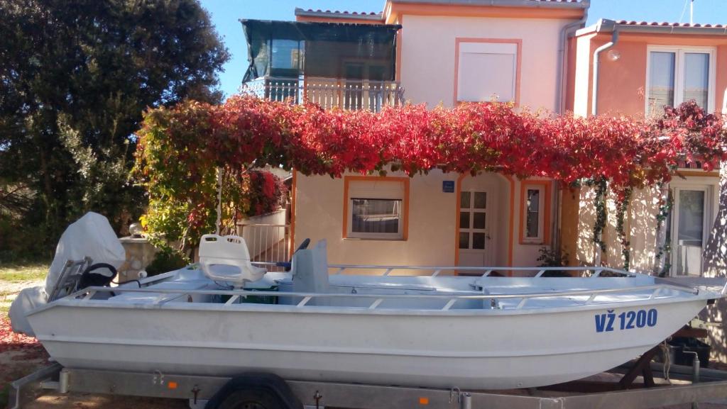 a boat parked in front of a house with flowers at Lubin in Sevid