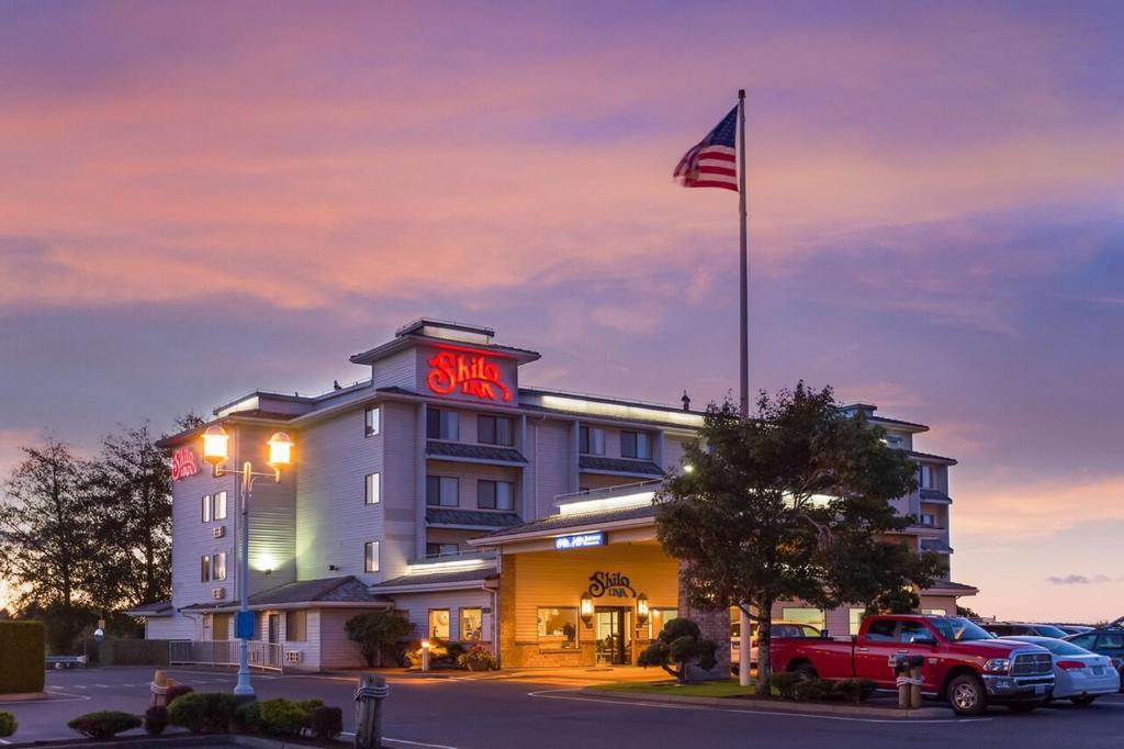 a hotel with an american flag on top of it at Shilo Inn Suites Warrenton in Warrenton
