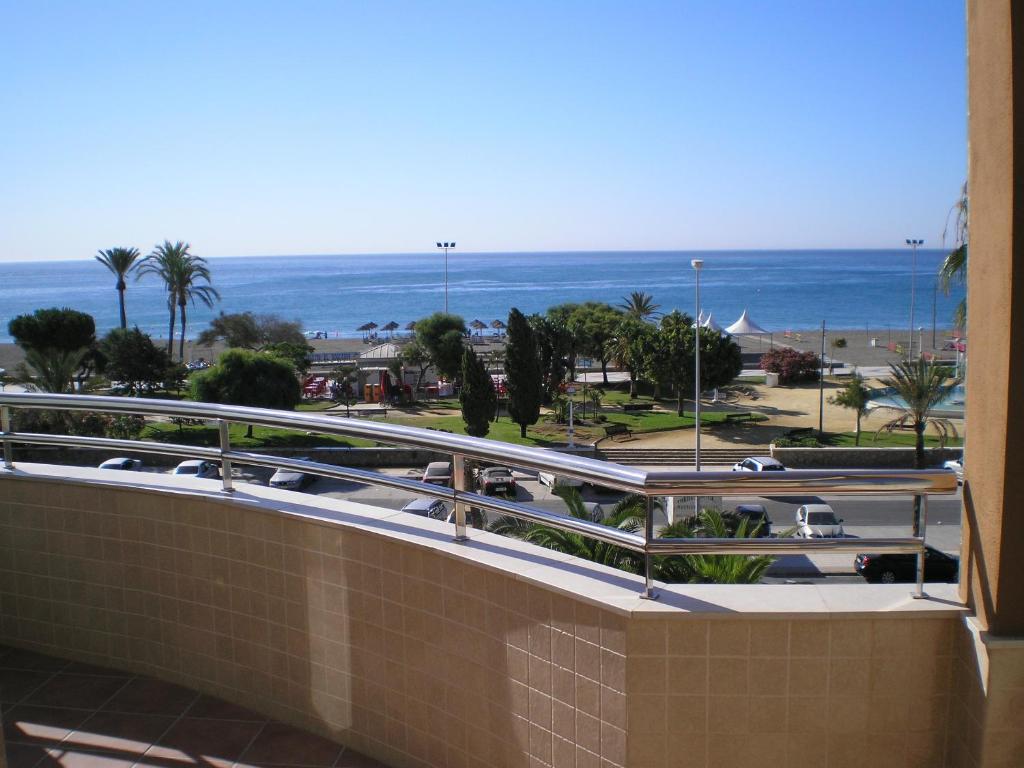 een balkon met uitzicht op het strand en de oceaan bij Hotel Miraya Beach in Torre del Mar