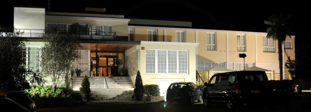 un grand bâtiment avec des voitures garées devant lui dans l'établissement Hotel Pintor Marsà, à Tárrega