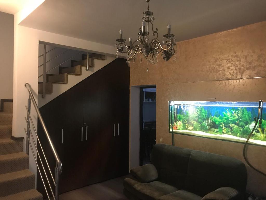 ein Wohnzimmer mit einem Aquarium und einem Sofa in der Unterkunft Bucharest Center Villa in Bukarest