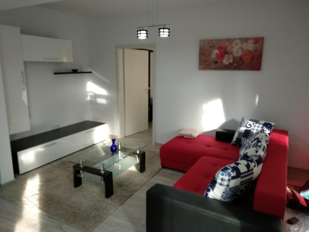 sala de estar con sofá rojo y mesa en Apartament Ramona en Braşov
