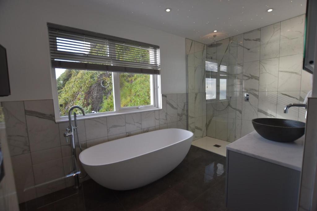 a bathroom with a large white tub and a sink at Watersmeet Hotel in Woolacombe