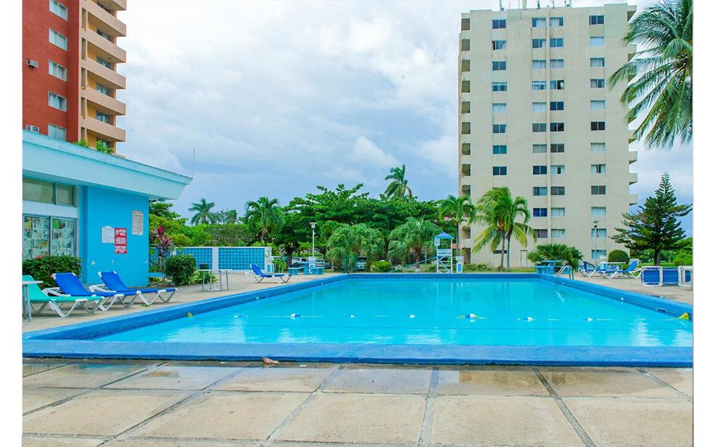 a large swimming pool in front of two tall buildings at Coconut Shell At Turtle Towers in Ocho Rios
