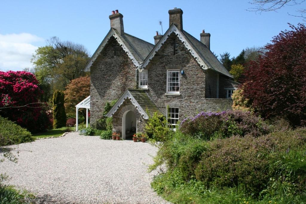 an old stone house with a gravel driveway at The Old Rectory in Boscastle