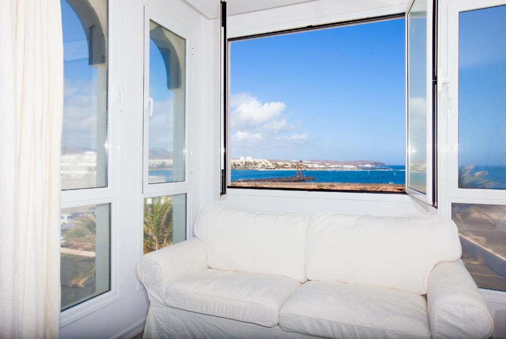 コスタ・テギセにあるAna Iris Playa de Jablilloの大きな窓付きの客室で、白いソファが備わります。