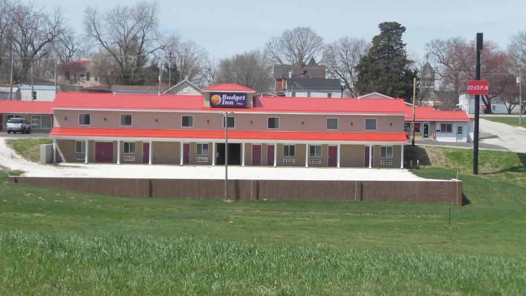 a large building with a red roof on a street at Budget Inn Palmyra in Palmyra