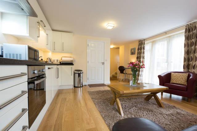 uma cozinha e sala de estar com uma mesa e um sofá em Oxford Apartments 1 em Oxford