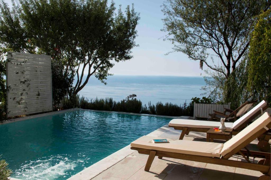 a swimming pool with a bench and a table at Yades Villas in Athanion