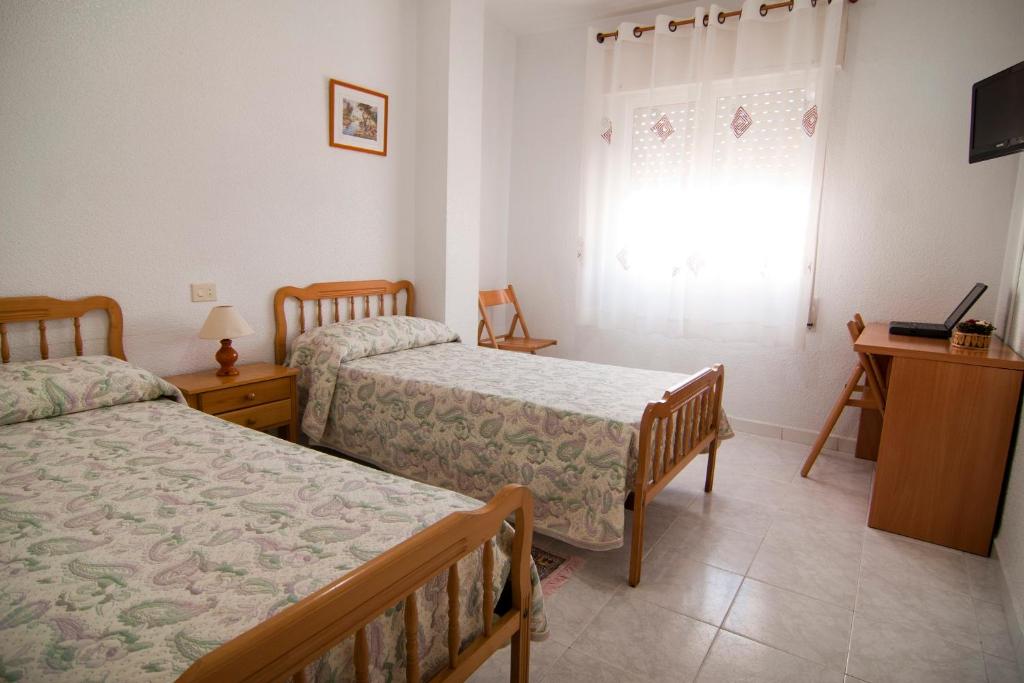 a bedroom with two beds and a window at La Obrera in Santiago de la Ribera