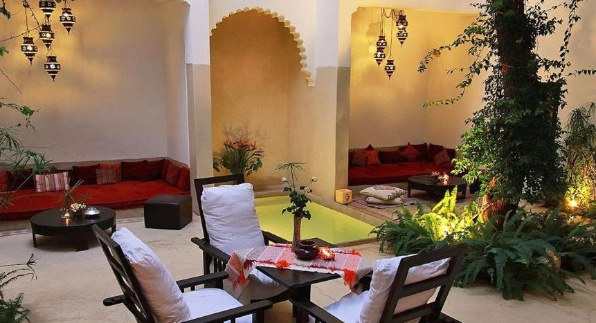 ein Wohnzimmer mit Stühlen, einem Tisch und einem Sofa in der Unterkunft Riad Davia in Marrakesch