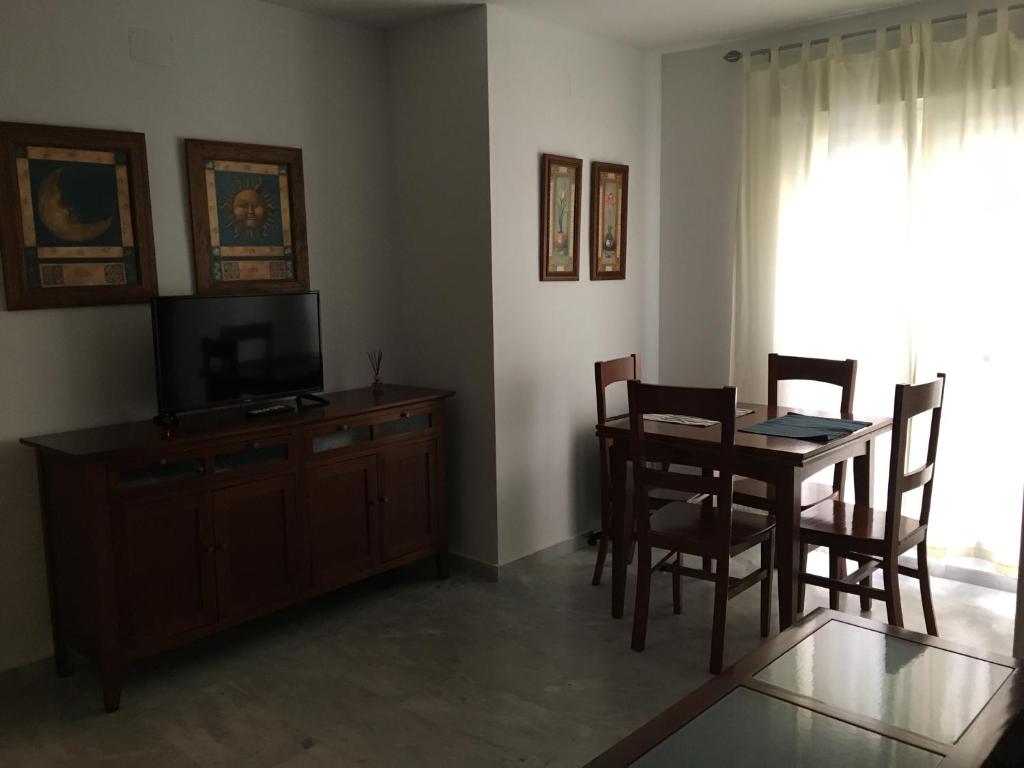 a living room with a dining room table and a television at Apartamento en el centro in Ceuta