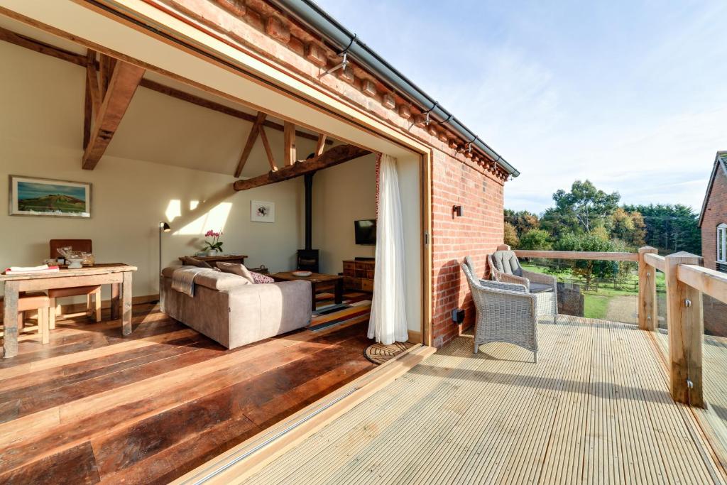 a living room with a deck with a couch and a table at The Stables and Hayloft in Ledbury