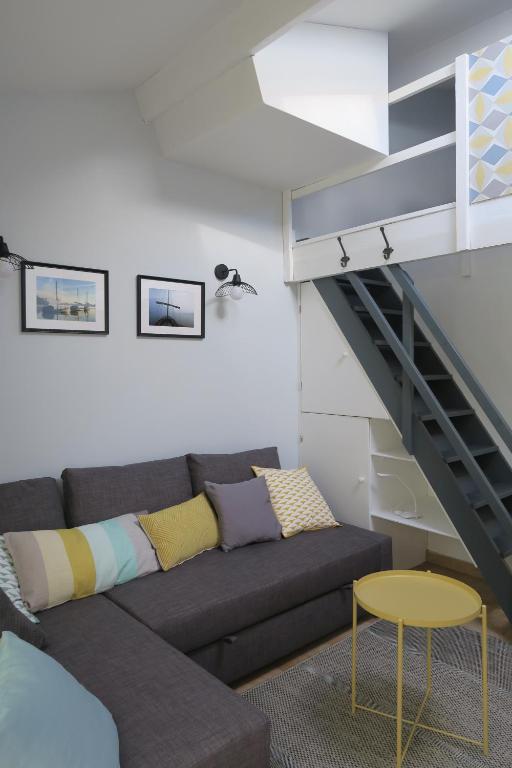 een woonkamer met een bank en een trap bij Gite Mona & Lisa in Amboise