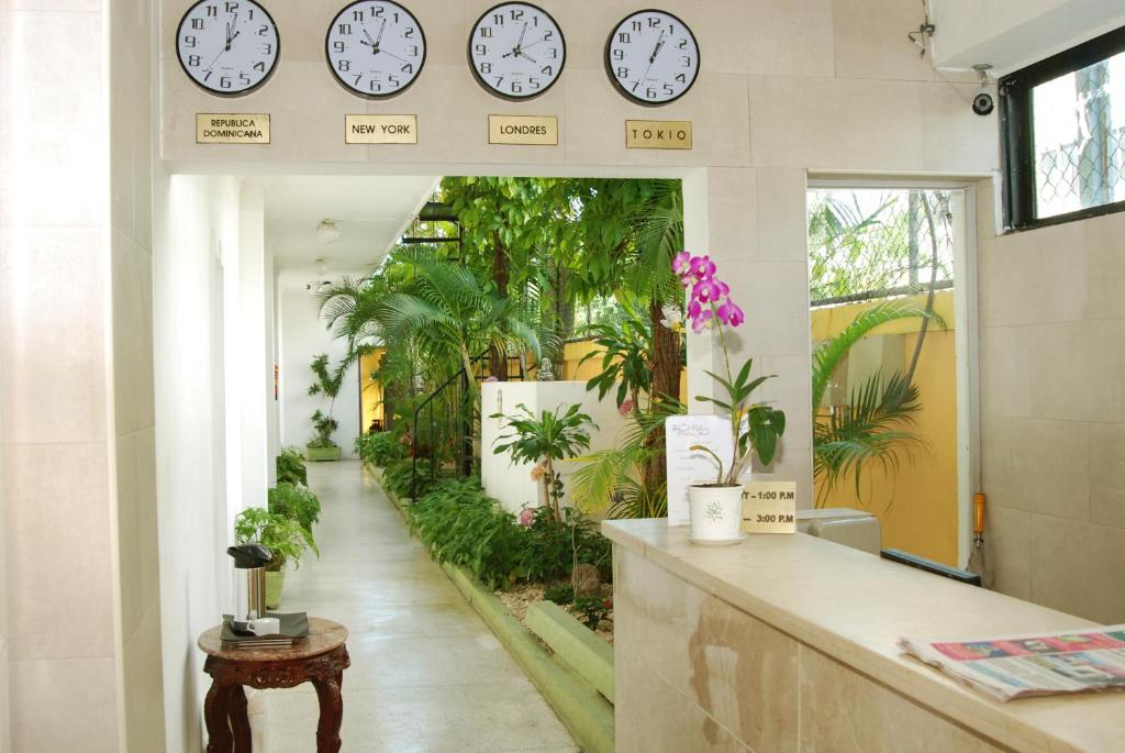 een kamer met klokken aan de muur en planten bij Royal Palace Hotel in Santo Domingo