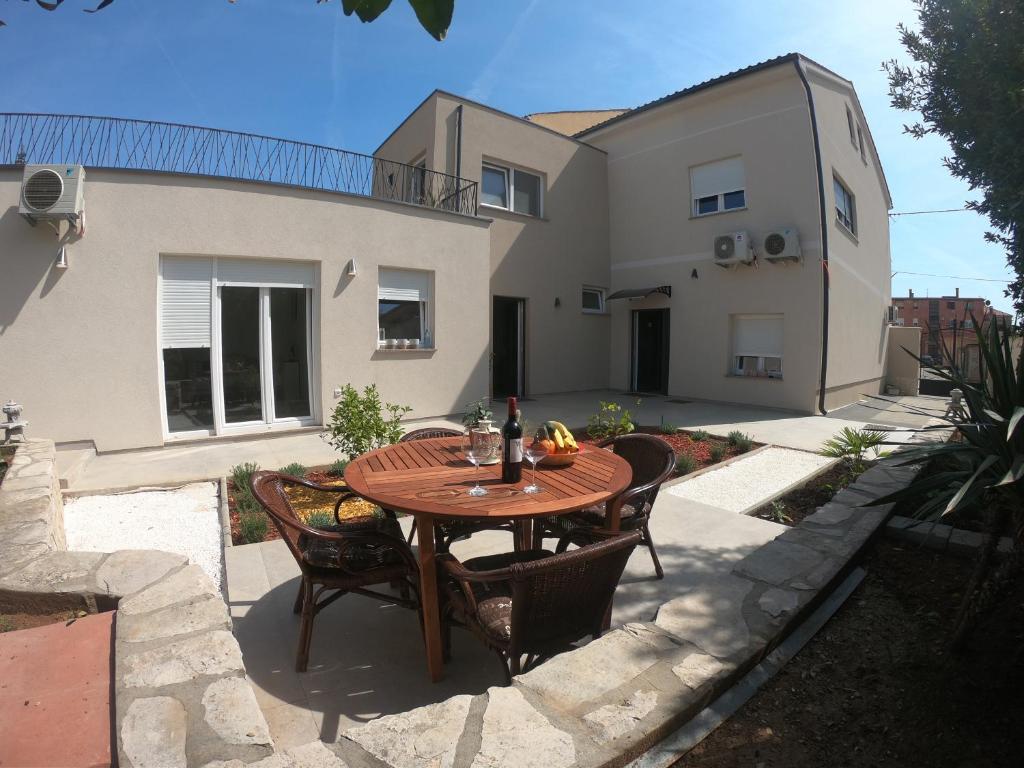 a patio with a wooden table and chairs at Faveria Apartments Amphitheater with FREE Parking in Pula