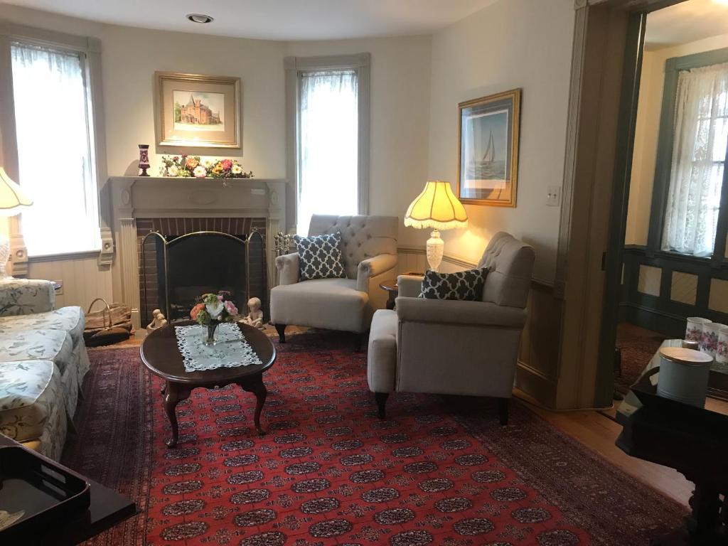 a living room with a couch and a fireplace at Parsonage Inn Bed and Breakfast in Saint Michaels