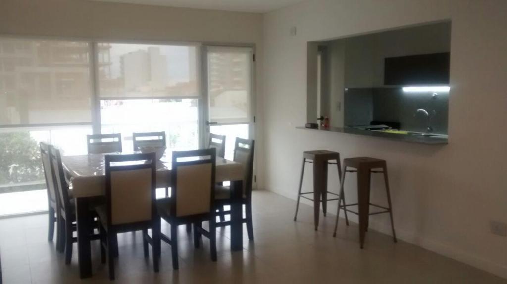 een eetkamer met een tafel en stoelen en een keuken bij Torre 1 Relax in Puerto Madryn