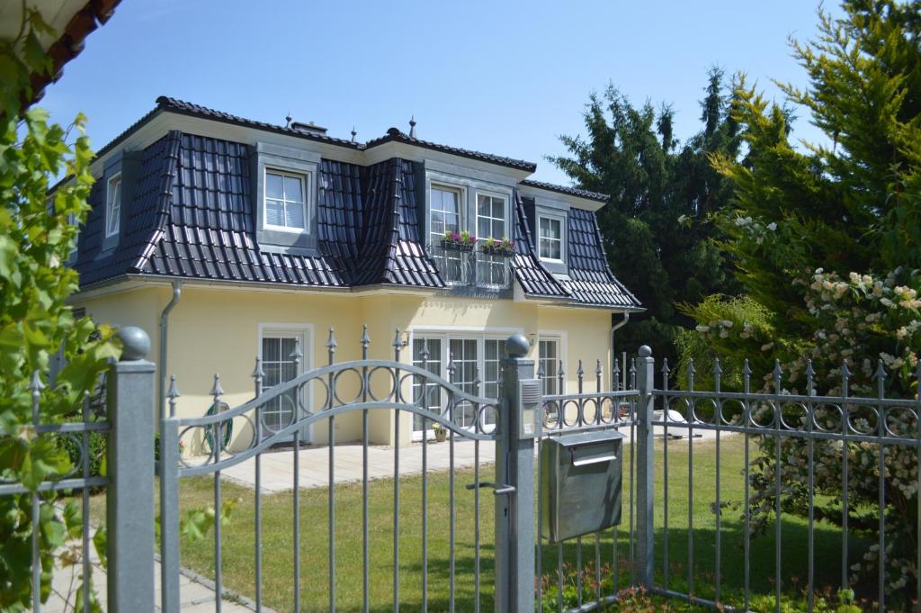 ein gelbes Haus mit schwarzem Dach in der Unterkunft Ferienwohnung Lucia in Bad Schlema