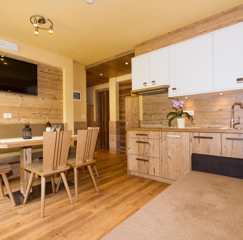 a kitchen with white cabinets and a table and chairs at Ferienwohnung & Spa Access Zimmerhofer in Cadipietra