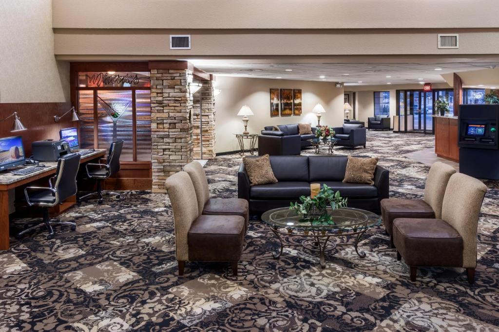 a lobby of a hotel with couches and a desk at Ramkota Hotel Watertown in Watertown