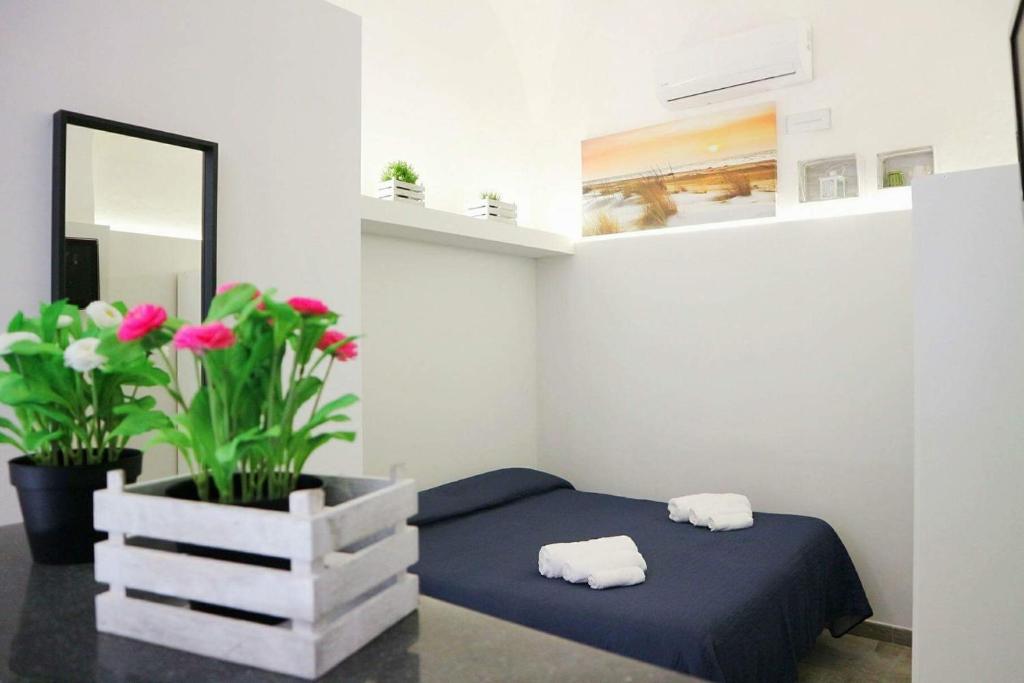 1 dormitorio con 1 cama, espejo y flores en Antica Civita, en Catania