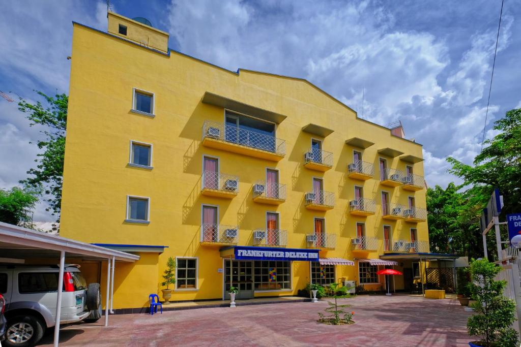 un edificio amarillo con ventanas y balcones en Frankfurter Deluxe Inn, en Cebú
