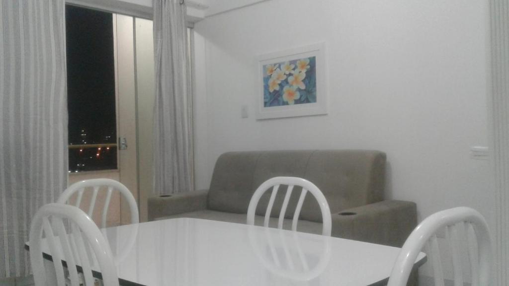 a table and chairs in a living room with a couch at Apartamento AV CPA in Cuiabá