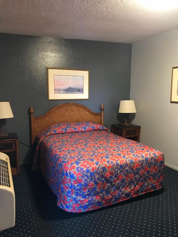 a hotel room with a bed and two lamps at Travelers INN in West Sacramento