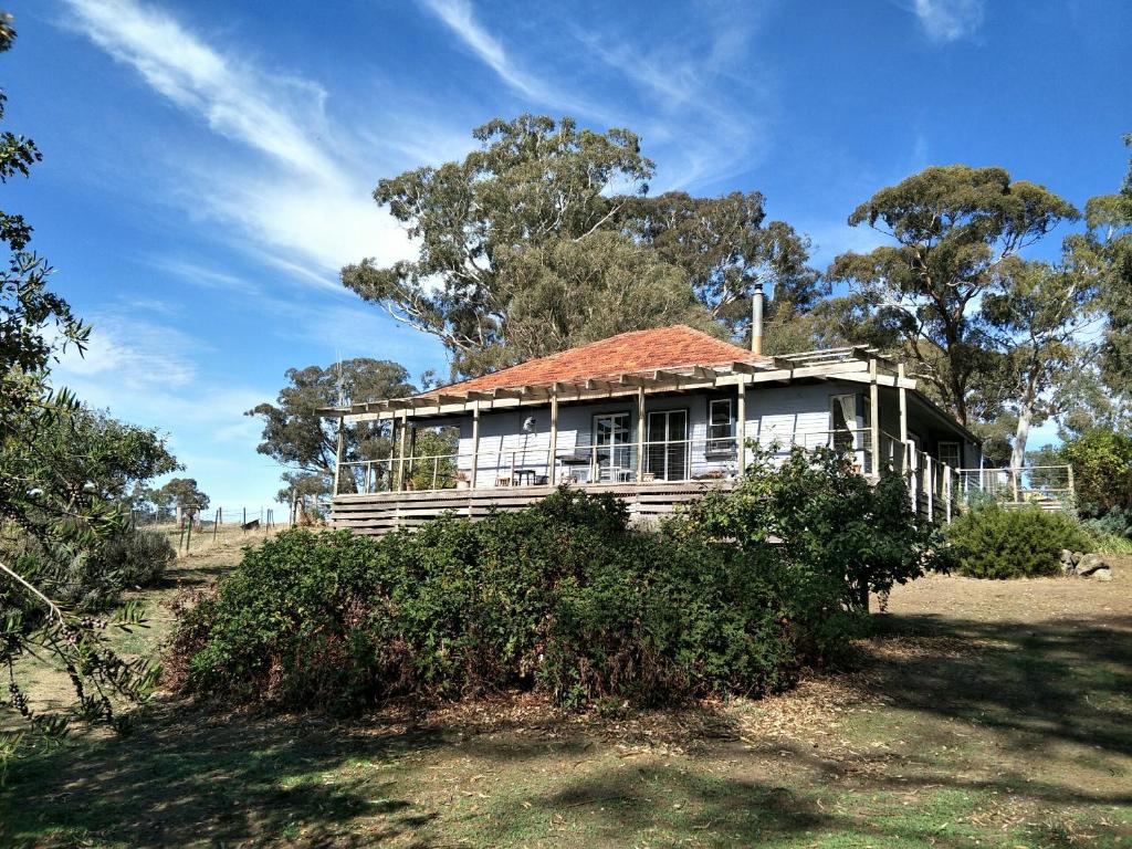 uma casa velha com um telhado vermelho num campo em Kinross Metcalfe Farm em Metcalfe