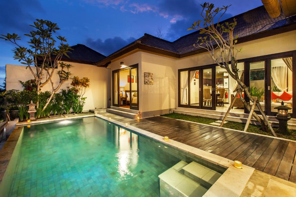 a villa with a swimming pool and a house at The Reika Villas by Nagisa Bali in Uluwatu