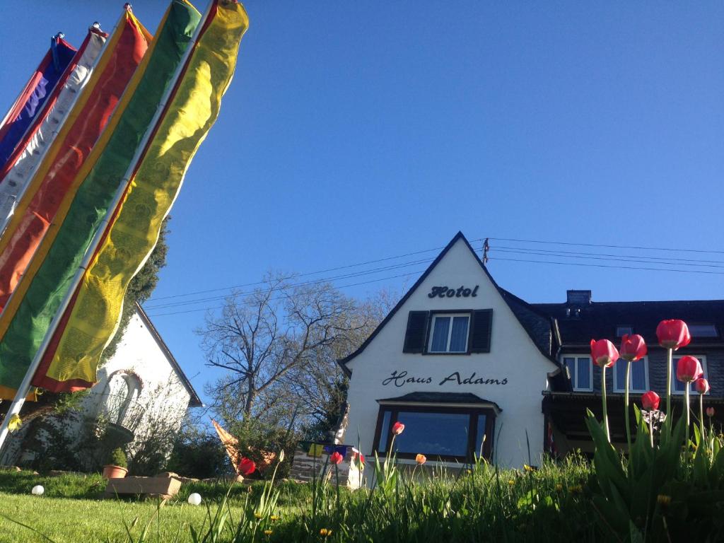 een wit huis met een bord erop bij Haus Adams - das Wohlfühl Gästehaus in Boppard