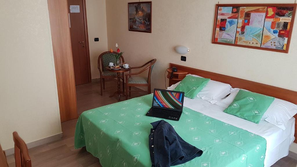 1 dormitorio con 1 cama con ordenador portátil en Hotel Aurora, en Vieste