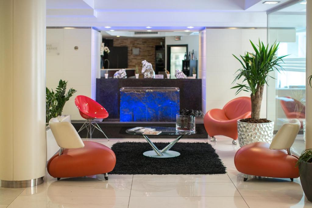 a lobby with red chairs and a fireplace at Best Western Plus Grand Hotel Victor Hugo in Luxembourg