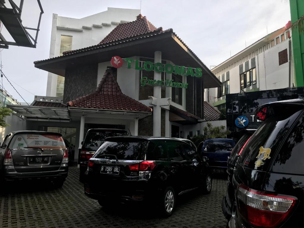 un gruppo di auto parcheggiate di fronte a un negozio di Tlogomas Guest House a Malang