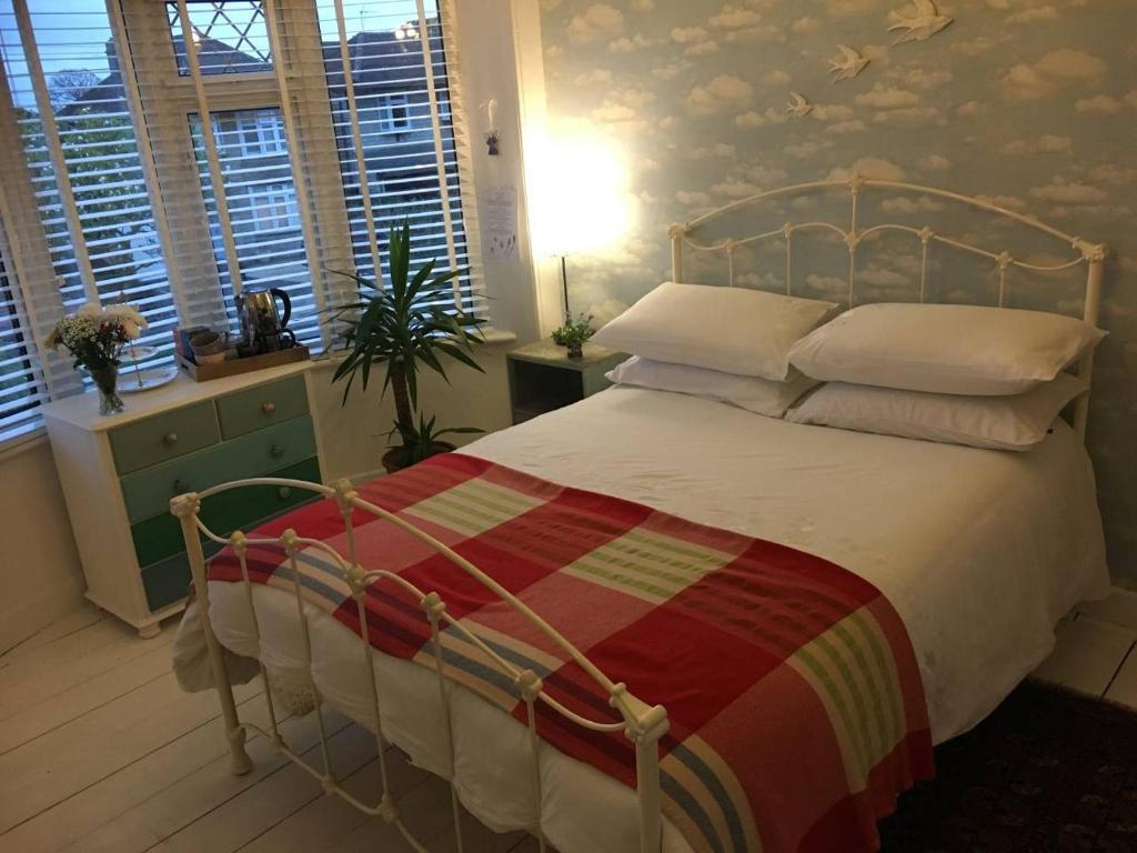 a bedroom with a large bed with a striped blanket at Heavenly Retreat in Corsham