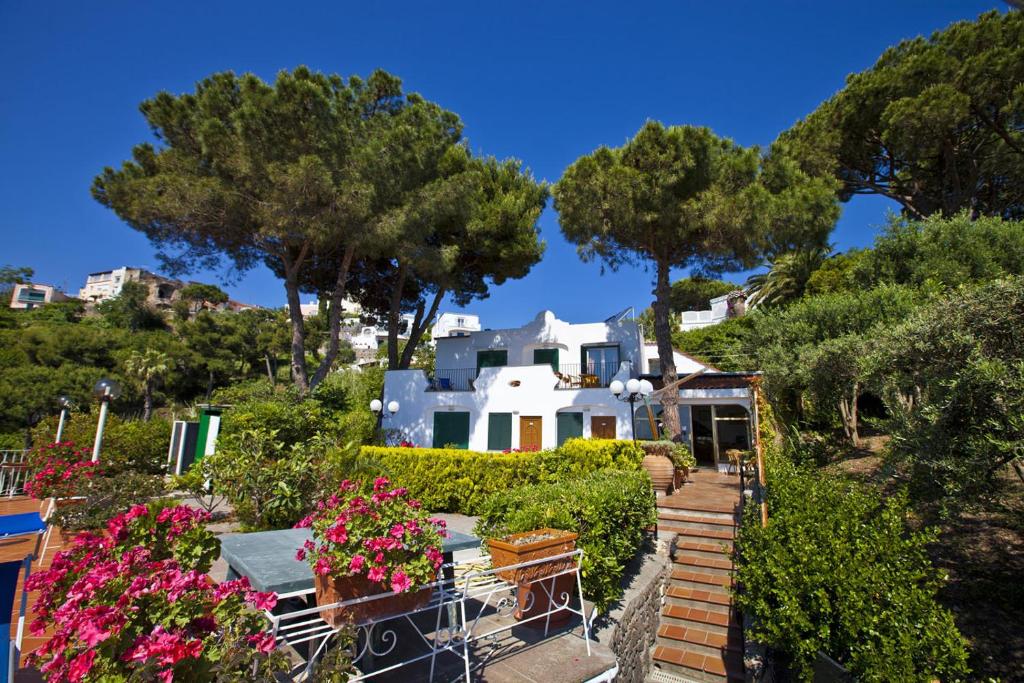 ein Haus auf einem Hügel mit Blumen und Bäumen in der Unterkunft Hotel Don Felipe in Ischia