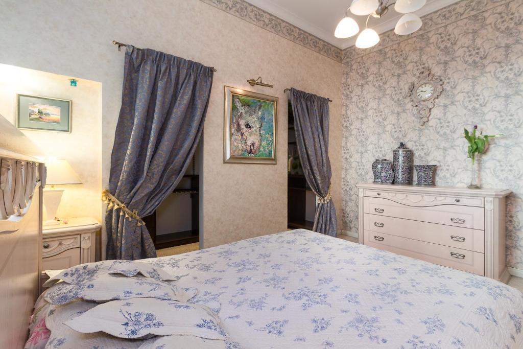 een slaapkamer met een bed en een dressoir bij Royal in Rīga
