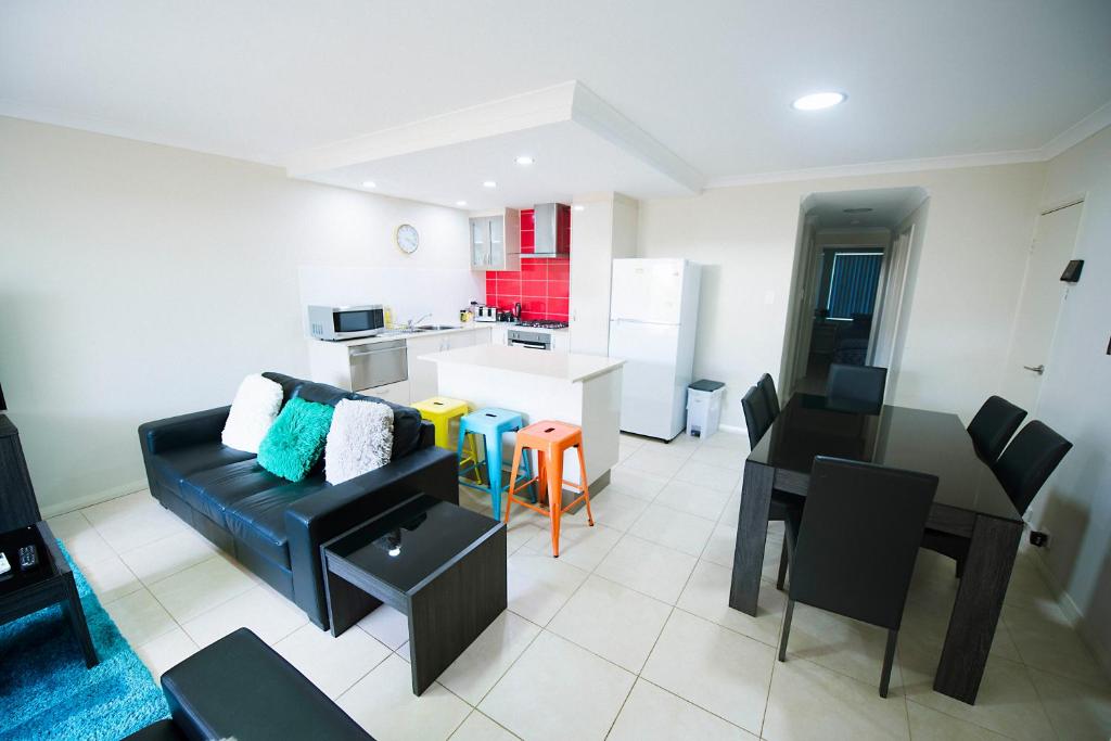 a living room with a black couch and a kitchen at Midland Haven - Midland WA in Midland Junction