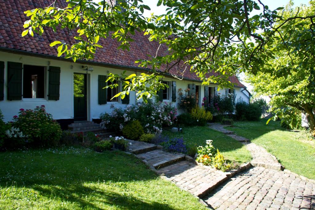 ein Haus mit einem Backsteinweg im Hof in der Unterkunft La Longère d'Ecottes in Licques