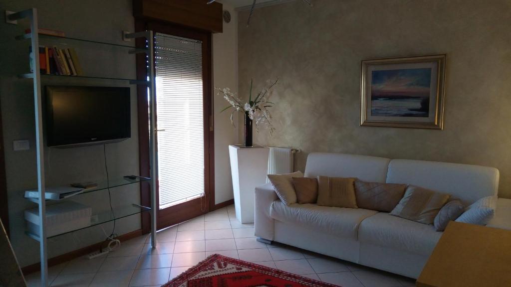 sala de estar con sofá blanco y TV en Atelier, en Portogruaro