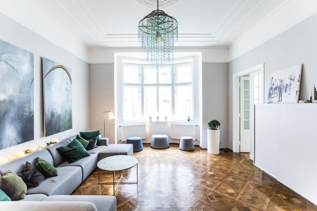 a living room with a couch and a chandelier at Warsaw Center 110 m2 Spacious and Elegant Apartment in Warsaw