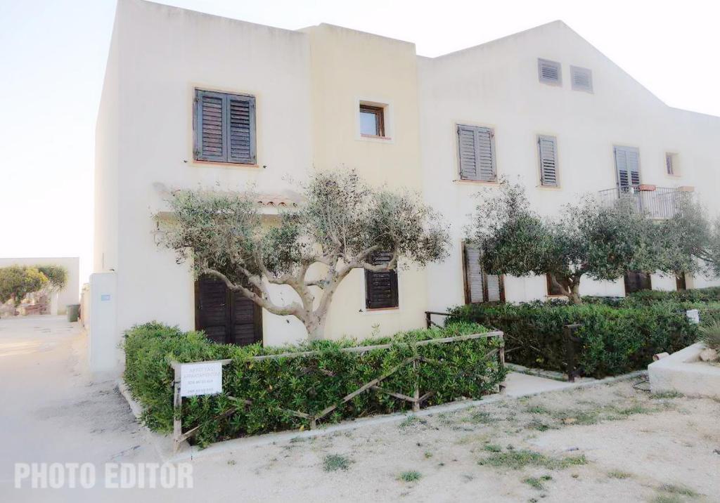 a white building with a tree in front of it at Torre Sances Holiday Apartament in Birgi Vecchi