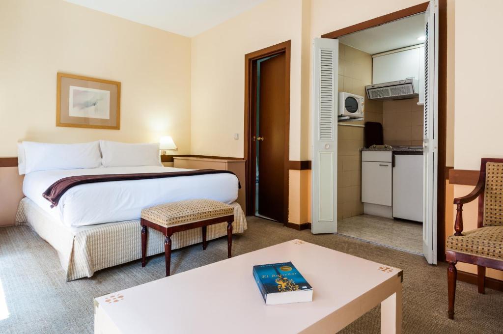 a hotel room with a bed and a table at Espahotel Plaza Basílica in Madrid
