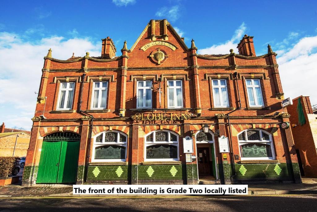 an old brick building with a green door at Globe Inn in Tamworth