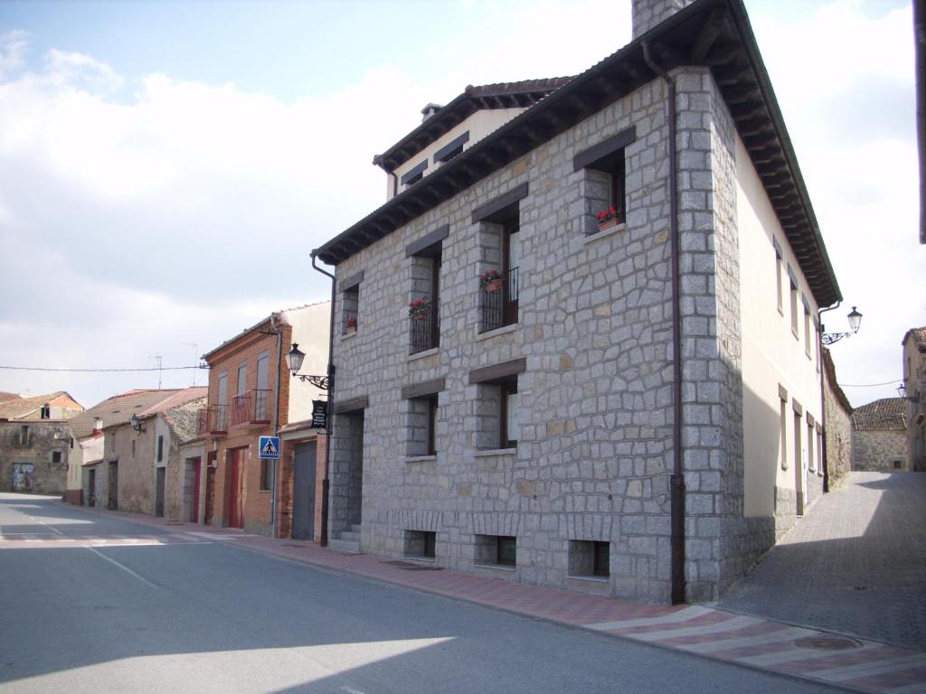 un edificio de ladrillo al lado de una calle en Casa Alval, en Villacastín